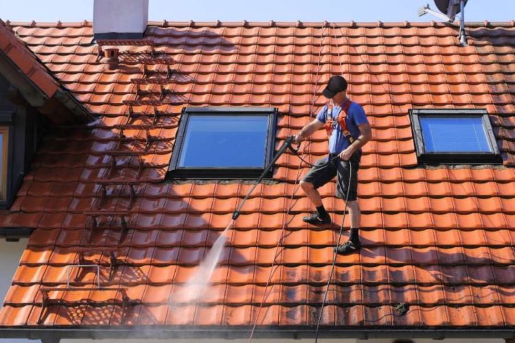 A Worker Performs Roof Maintenance, Cleaning the Tiles in South Florida