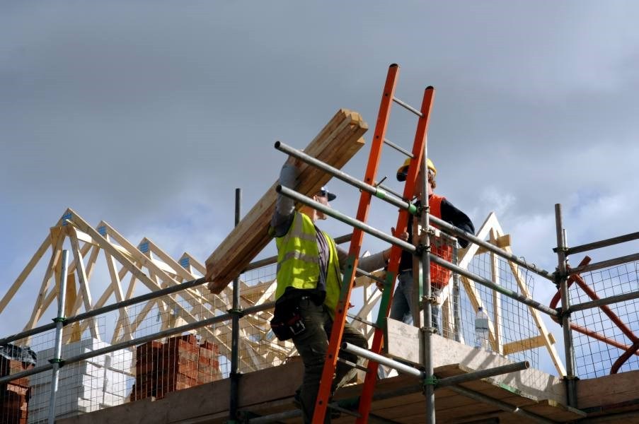 Team of Workers on a Roof with Scaffolding Engaged in Roofing Services at South Florida