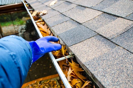 A person cleaning a gutter