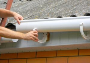 A person installing a gutter