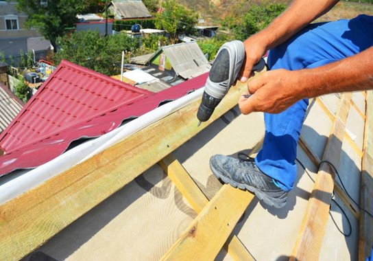 A person using a drill to fix a roof